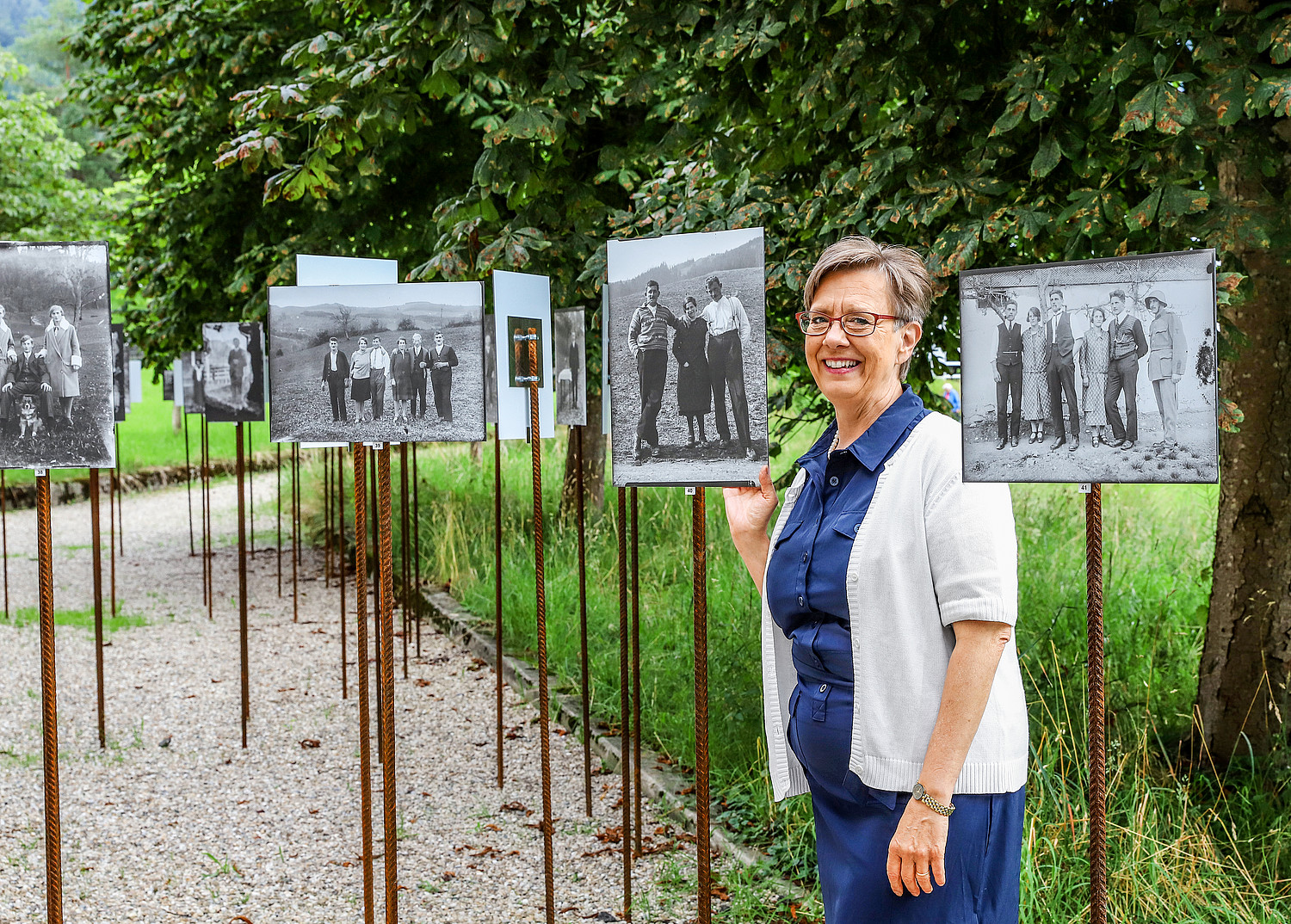 Christine Bouvard inmitten von Bildern der Freilicht-Ausstellung «Leute aus dem Entlebuch» beim Entlebucherhaus, Schüpfheim.