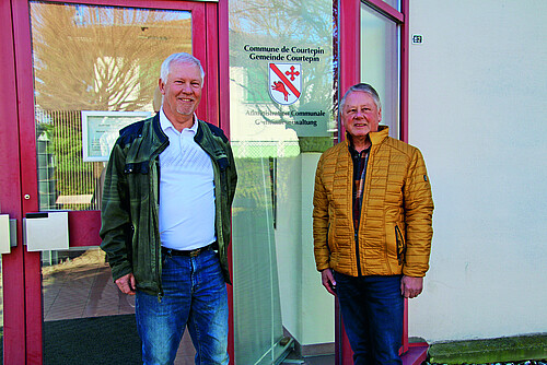Gemeindepräsident Martin Moosmann (links) und Peter Grünig, Präsident des Generalrats 2023-2024, vor der Gemeindeverwaltung von Courtepin (FR).