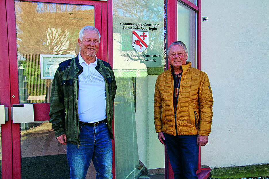 Gemeindepräsident Martin Moosmann (links) und Peter Grünig, Präsident des Generalrats 2023-2024, vor der Gemeindeverwaltung von Courtepin (FR).