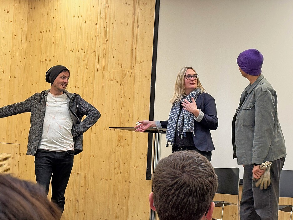 Die Schauspielerinnen und Schauspieler stellen auf der Bühne Alltagsszenen nach.