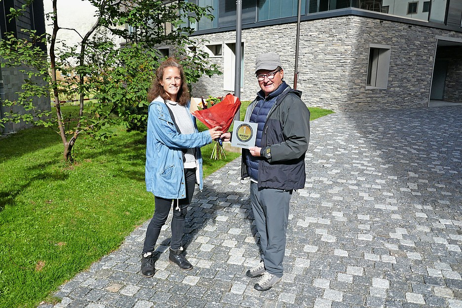 Gemeinderat von Andermatt Erich Renner und Projektleiterin Minergie-Rating Geraldine Chew bei der Plakettenübergabe.